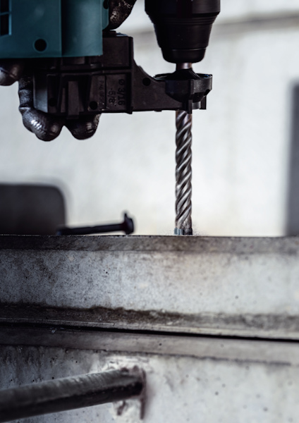 Borrmaskin borrar genom betong med en spiralborr.