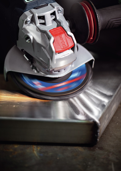 Vinkelslip används vid metallbearbetning; gnistor flyger från skärytan.