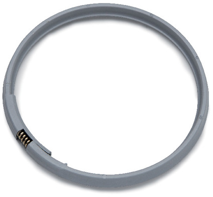 Klämring i grå plast med metallfjäder, sett ovanifrån. Ringen är rund och har en jämn yta.