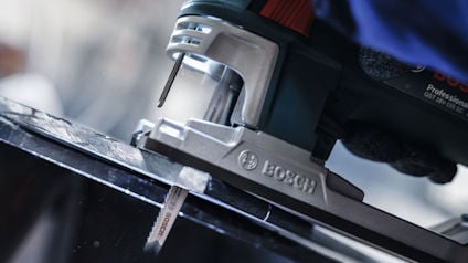 Sticksåg från Bosch skär genom en svart yta.