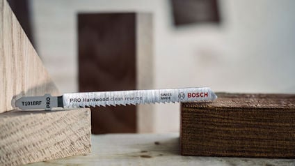 Sticksågblad märkt "PRO Hardwood clean reverse SWISS MADE BOSCH" placerat på träplankor.