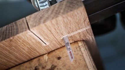 Träbit sätts i såg med bimetallblad, Bosch-logotyp synlig på bladet.