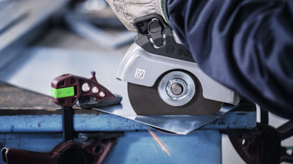 En person slipar metall med en vinkelslip, gnistor flyger.