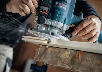 Man använder en Bosch Pro-handöverfräs på en träbit.