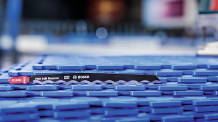 Vågtandad sågklinga märkt "Bosch PRO Soft Material" placerad på blå bakgrund.