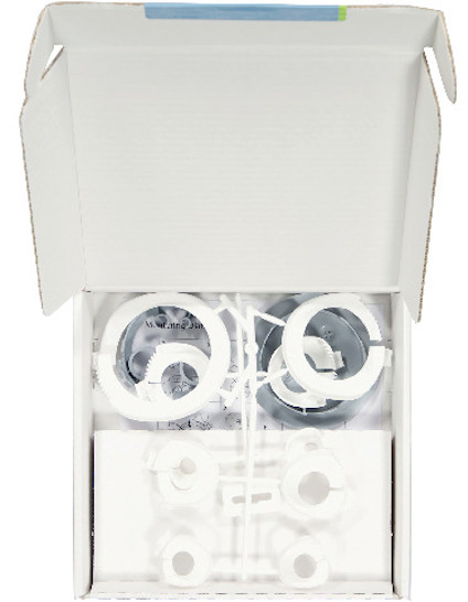 Vit kartong med öppet lock innehållande cirkelformade plastdelar i vitt och transparent material.